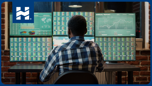 Qué es el trading; hombre de espaldas visualizando información en varias pantallas